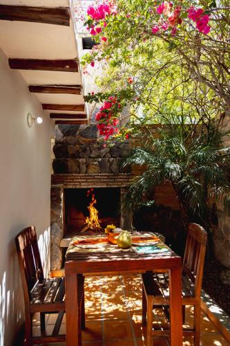a table and chairs in front of a fireplace at VoyAca Hotel - Alfareria in Villa de Leyva