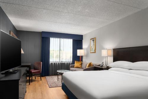 a hotel room with a bed and a living room at DoubleTree by Hilton Bradley International Airport in Windsor Locks