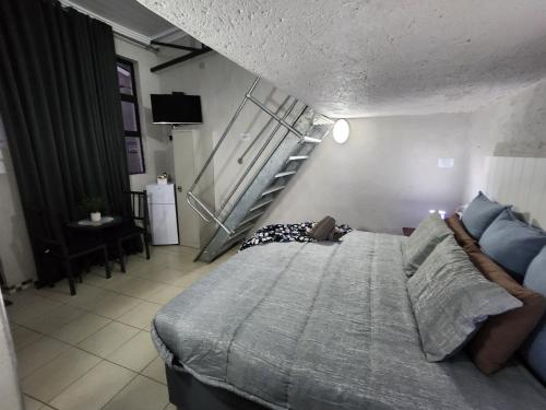 a bedroom with a large bed and a staircase at 9 Levubu Cottages in Polokwane