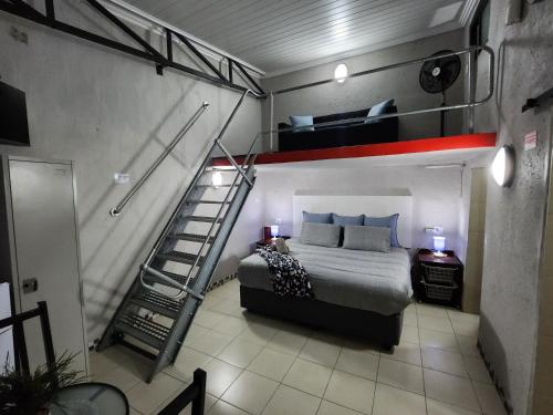 a bedroom with a bunk bed and a ladder at 9 Levubu Cottages in Polokwane