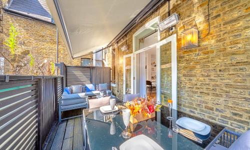 a balcony with a table and chairs on a building at DESIGNER Victorian Flat with HUGE Terrace in London