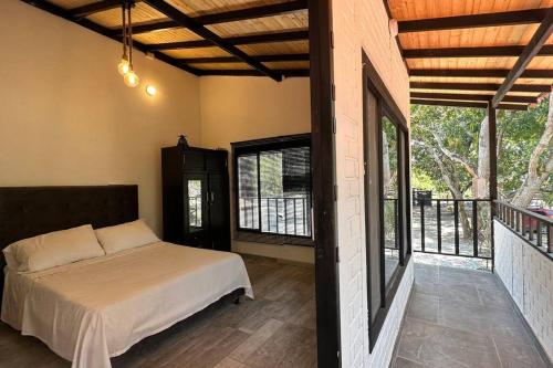 a bedroom with a bed and a balcony at Moderna casa campestre in Guamo
