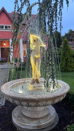 a statue of a woman sitting in a fountain at Ferienwohnung Magdalena in Königs Wusterhausen