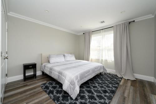 a white bedroom with a bed and a window at Belmar NJ 5 Min Walk to Beach in Belmar