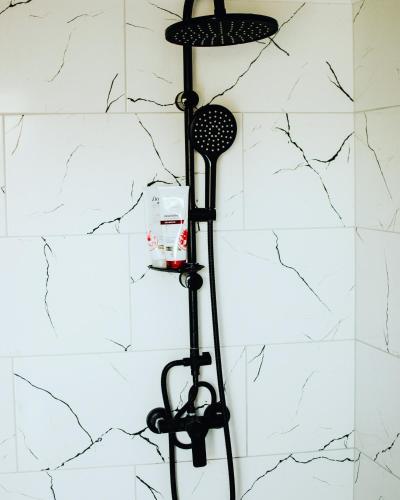 a shower rack in a bathroom with a white wall at Holiday House Maya in Mostar