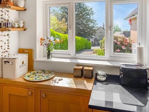 a kitchen with two windows and a counter top at Little Saxby in Crowborough