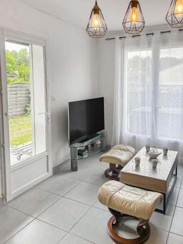 un salon avec une télévision et une table basse dans l'établissement Détente à la Plage à Les Mathes, aux Mathes