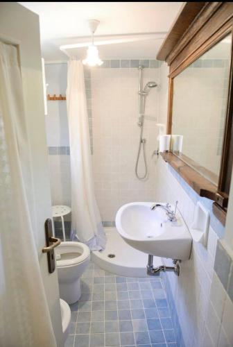 a bathroom with a sink and a toilet and a shower at Casa rio Lera in Amandola