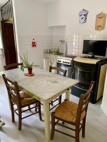 a kitchen with a table and chairs and a television at Casa rio Lera in Amandola