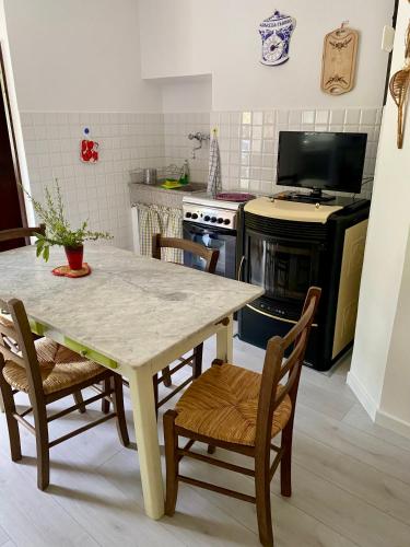 a kitchen with a table and chairs and a tv at Casa rio Lera in Amandola