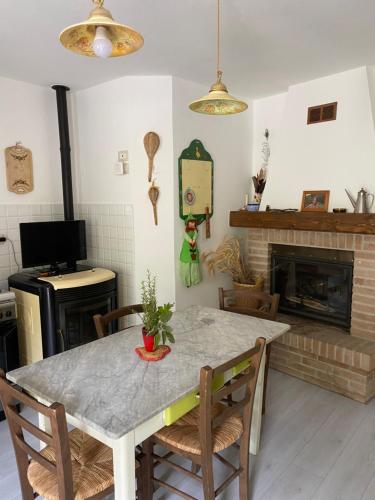 a dining room with a table and a fireplace at Casa rio Lera in Amandola