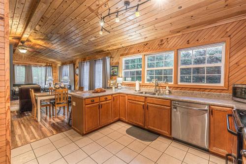 eine Küche mit Holzschränken und ein Esszimmer mit einem Tisch in der Unterkunft Diamond Creek Cabin in Bryson City