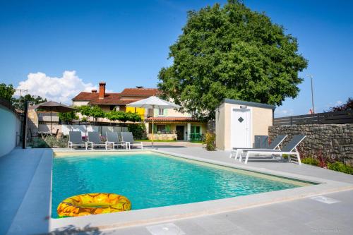 a swimming pool with chairs and a house at House Ladonja with private pool in Bale
