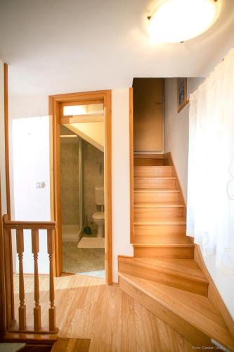 a hallway with a wooden staircase in a house at House Ladonja with private pool in Bale