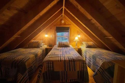 a room with three beds in a attic at Cozy Cove Cottage Winter Rental Available in Belgrade