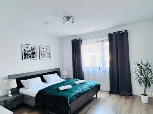 a bedroom with a bed with two towels on it at Moderne, helle Wohnung mit Terasse 15min bis OB Centro, Klimaanlage in Dinslaken