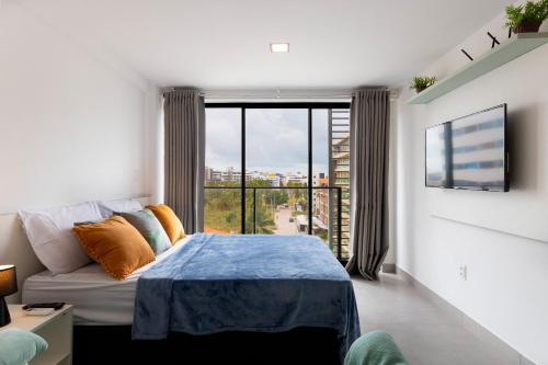 a bedroom with a bed and a large window at Neo Duos #505 - Intermares por Carpediem in Ilha da Restinga