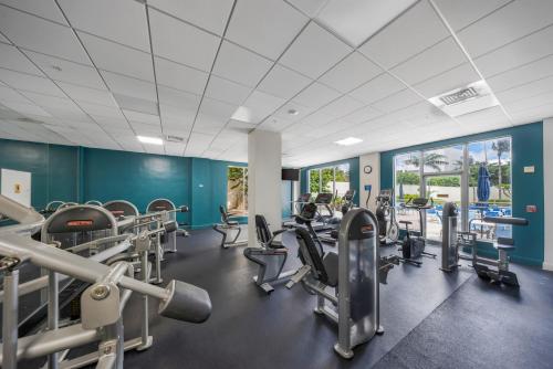 a gym with cardio equipment and blue walls at Oceanfront Luxury Condo with Stunning Views and Resort Amenities in Hollywood