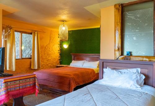 a bedroom with two beds and a tv in it at Hospedaje Campo Lago y Glamping in Otavalo