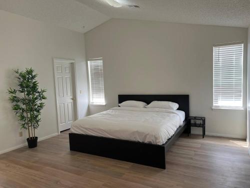 a bedroom with a bed and a potted plant at Extended Stay 3 or 4 Beds Cozy Smart Home Living in Las Vegas