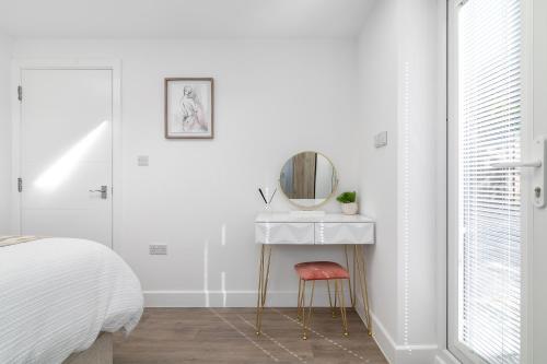 a bedroom with a dressing table and a mirror at Flat in Queens Park in London