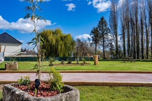a park with a tree in a stone planter at Le noé in Caen