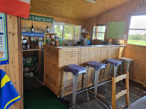 - un bar avec tabourets violets dans une pièce dans l'établissement Camping des ch tis, à Saint-Sylvain-Bellegarde