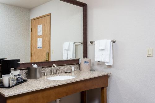 a bathroom with a sink and a large mirror at Yuma Inn & Suites in Yuma