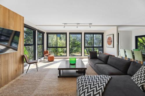 a living room with a couch and a table at Station Penthouse with Private Spa in Warburton
