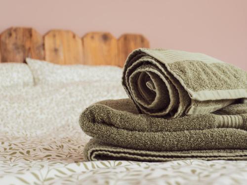 une pile de serviettes posée sur un lit dans l'établissement Le Jardin de Buna - proche Europa Park, à Schoenau