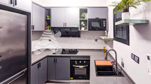 a kitchen with black and white cabinets and a stove at Ahoefa les Résidences in Lomé