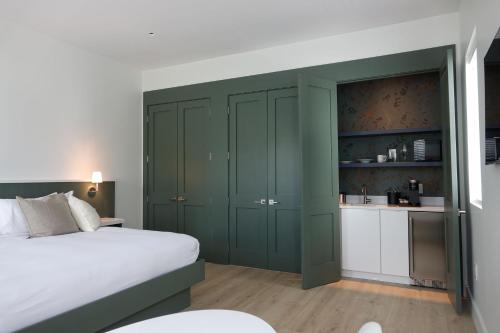 a bedroom with green cabinets and a white bed at Whitetail Court Hotel in Fredericksburg