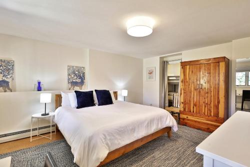 a bedroom with a large white bed with blue pillows at Wobbly Cabin - 2 Bedroom - Charming Ski Home - Fireplace - WiFi - Close to Resort in Killington