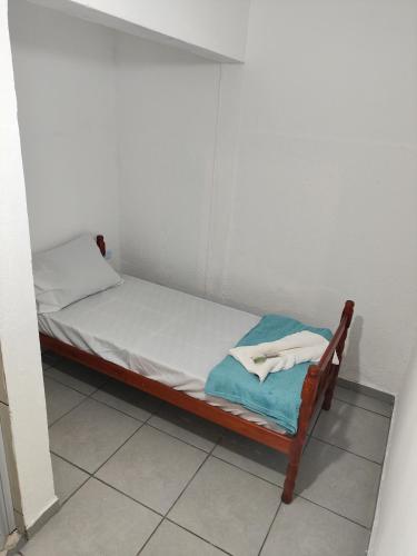 a small bed with white sheets and towels on it at Olegário Bueno 230 in Hortolândia