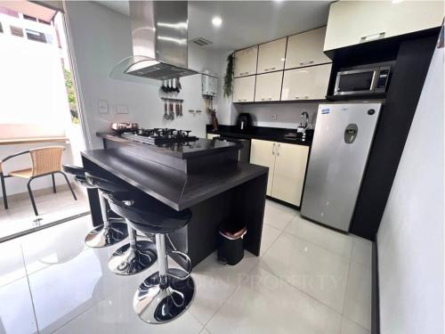 a kitchen with a stove and a refrigerator at Luxury Studio in El Poblado Modern Charm in Envigado