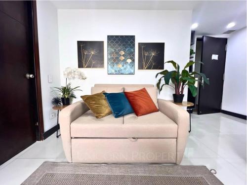 a living room with a couch with pillows on it at Luxury Studio in El Poblado Modern Charm in Envigado