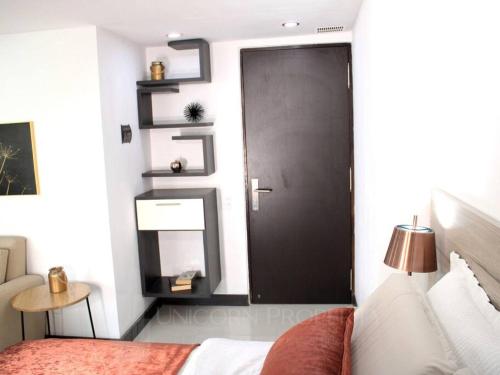 a bedroom with a bed and a black door at Luxury Studio in El Poblado Modern Charm in Envigado