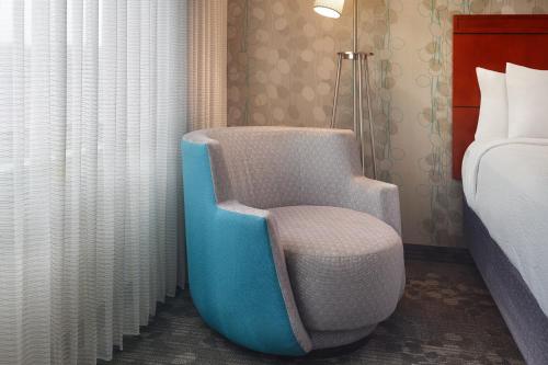 a room with a chair next to a bed at Courtyard by Marriott Nashville Goodlettsville in Goodlettsville