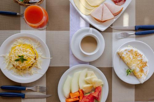een tafel met borden eten en een kopje koffie bij Pousada Lenda das Águas in Fernando de Noronha