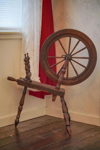 a wooden spinning wheel sitting in front of a flag at Weaverville Hotel in Weaverville