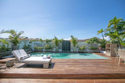 une cour arrière avec une piscine et une terrasse avec une chaise longue dans l'établissement Casa Belle Cartagena Hotel Boutique, à Carthagène des Indes