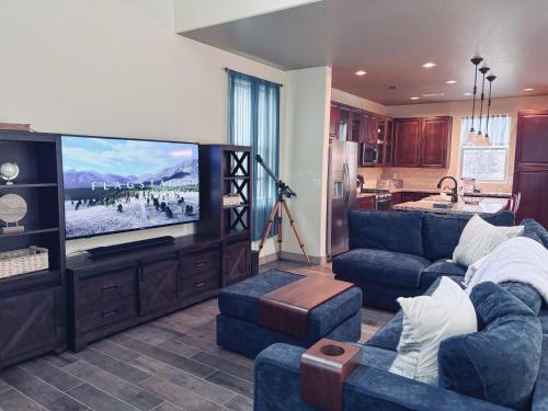a living room with a blue couch and a flat screen tv at Fun & Peaceful Family Retreat in Flagstaff