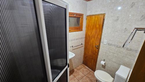 a bathroom with a shower and a toilet and a sink at Cabañas Rincon Santa Maria in Puerto Iguazú