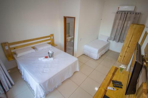 a bedroom with a white bed and a television at Villa Coco Beach Preá in Prea