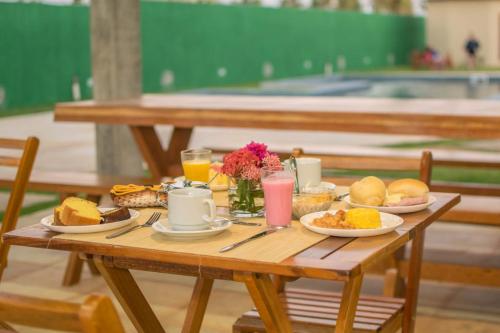 a wooden table with breakfast foods and drinks on it at Villa Coco Beach Preá in Prea