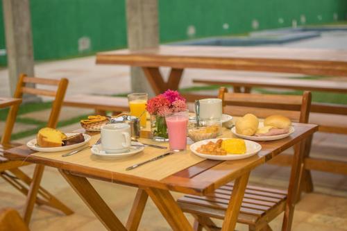 a wooden table with plates of food on it at Villa Coco Beach Preá in Prea
