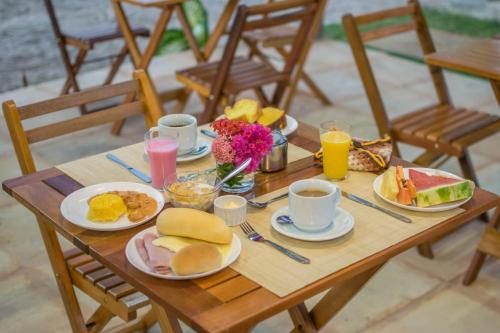 a wooden table with breakfast foods and drinks on it at Villa Coco Beach Preá in Prea