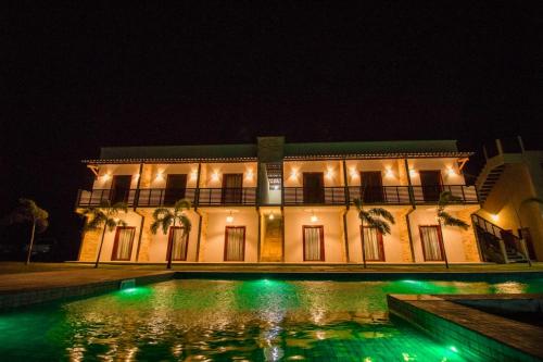 a building with a pool in front of it at night at Villa Coco Beach Preá in Prea