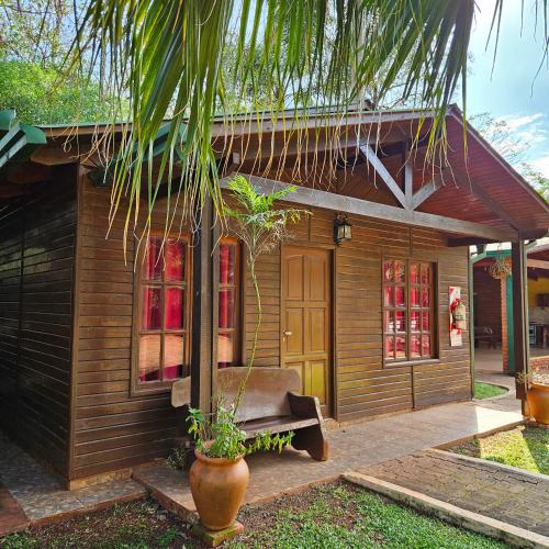 a wooden house with a bench in front of it at Cabañas Rincon Santa Maria in Puerto Iguazú