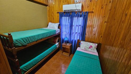 a small room with two bunk beds and a window at Cabañas Rincon Santa Maria in Puerto Iguazú